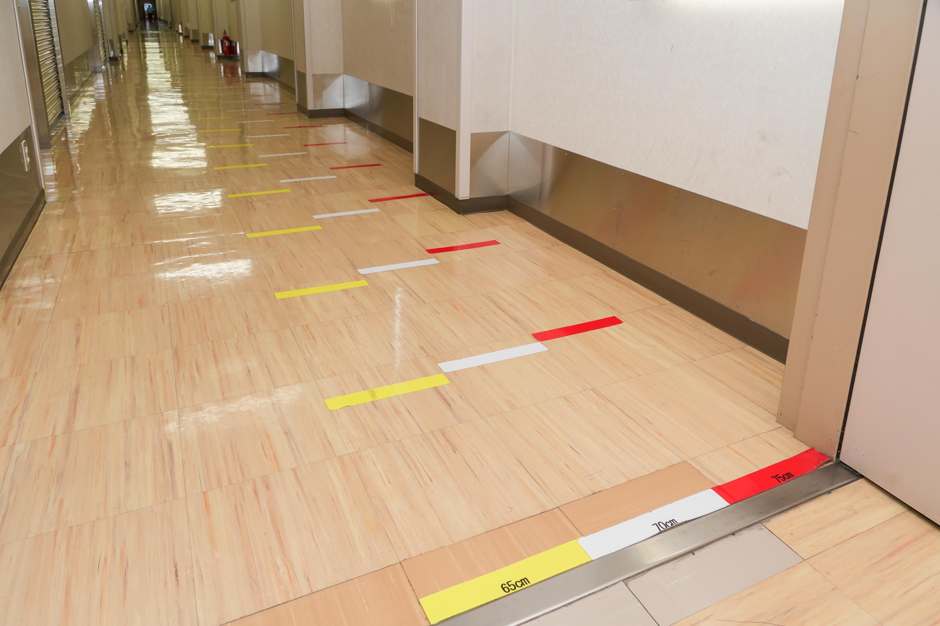 廊下の一部に理想的な歩幅を示すラインテープ