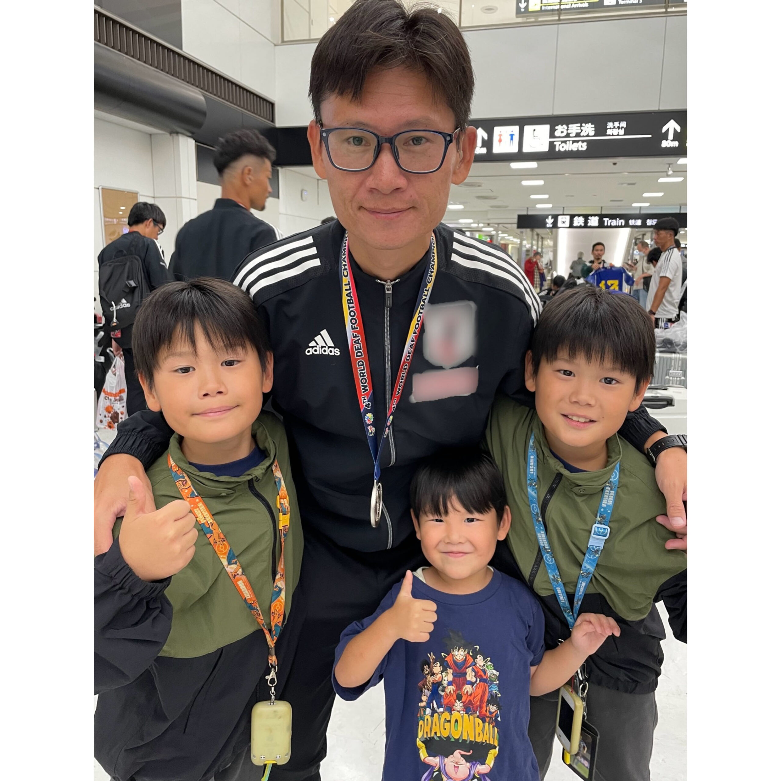 空港で3人の子供たちといっしょに写る植松さんの写真