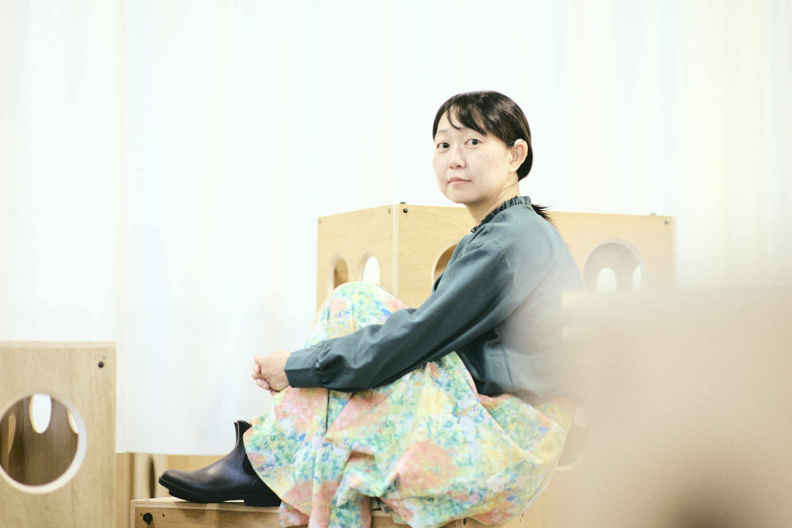体育座りでこちらを見つめている菊永さんの写真