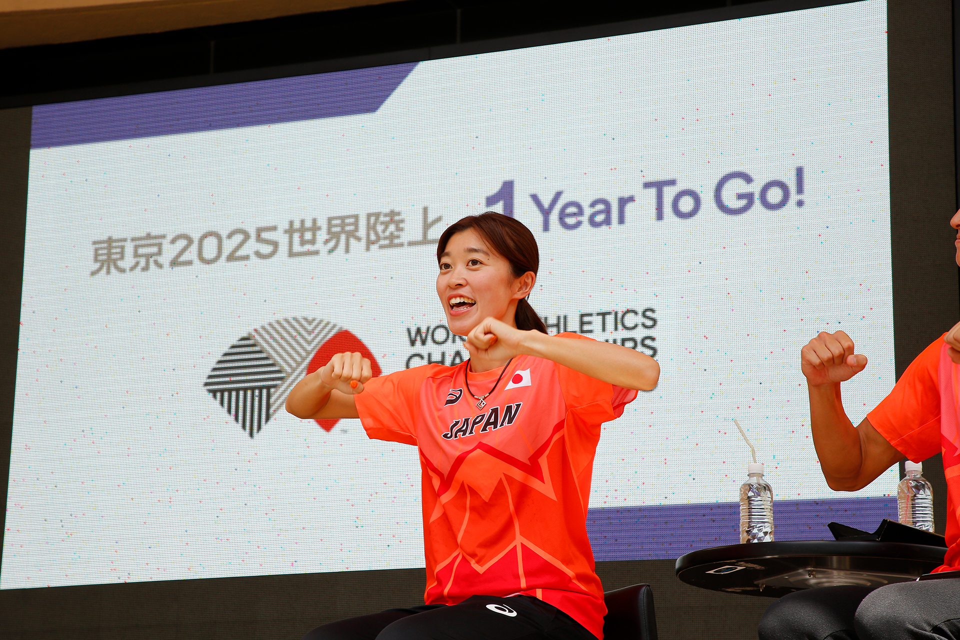 岡田選手が頑張れの手話をしている写真