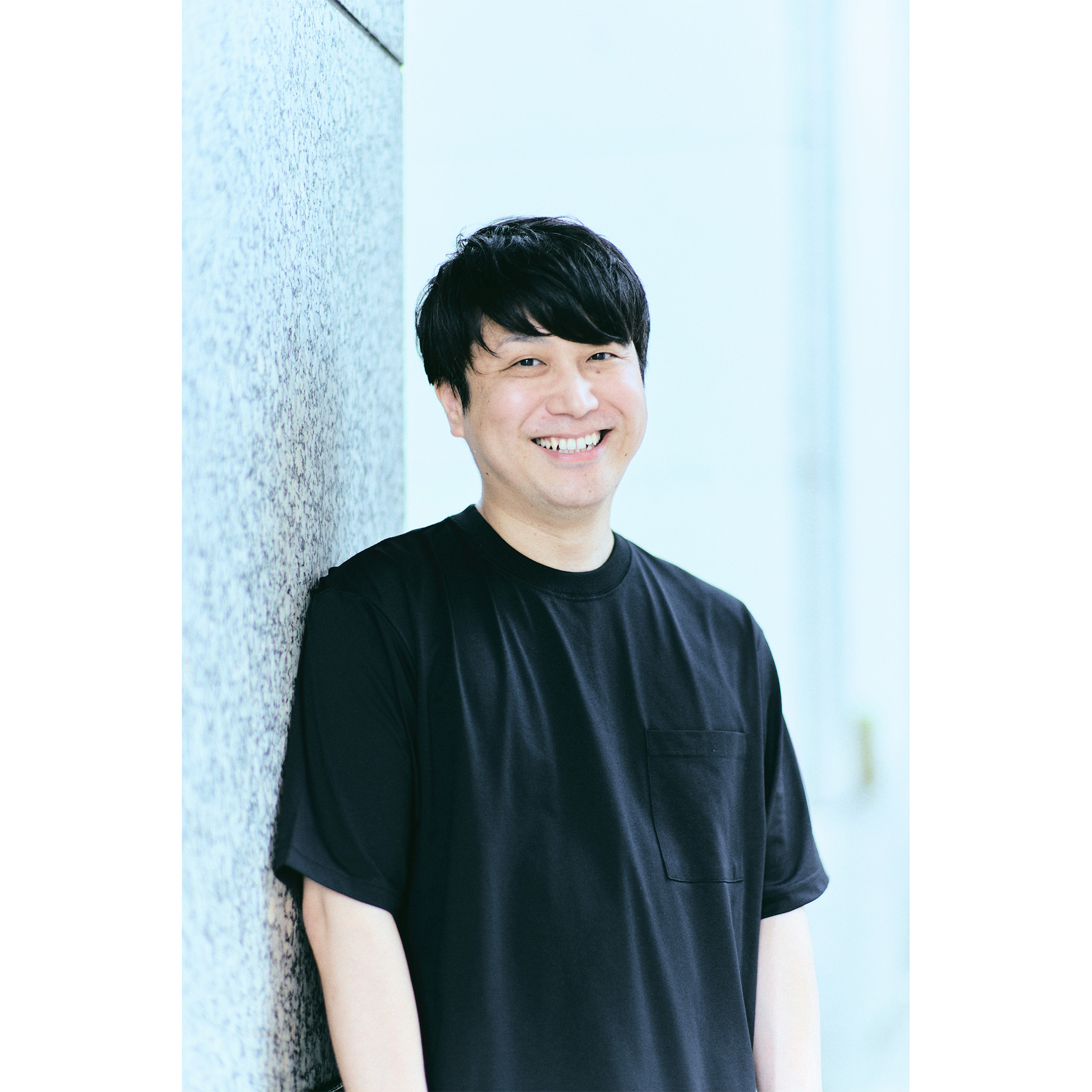 壁にもたれている五十嵐さんの写真
