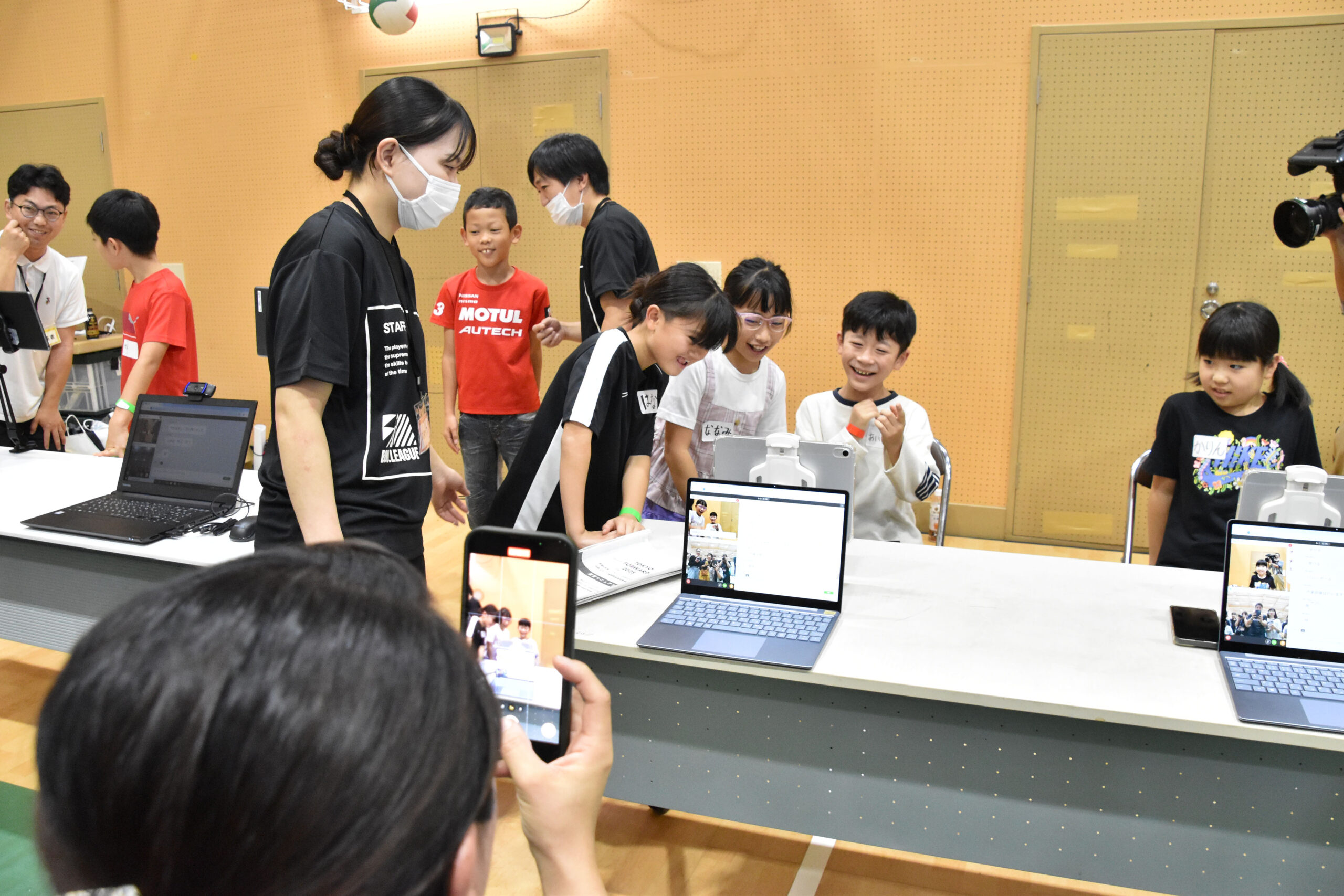 笑いながらタブレットを見ている参加者とスタッフの写真