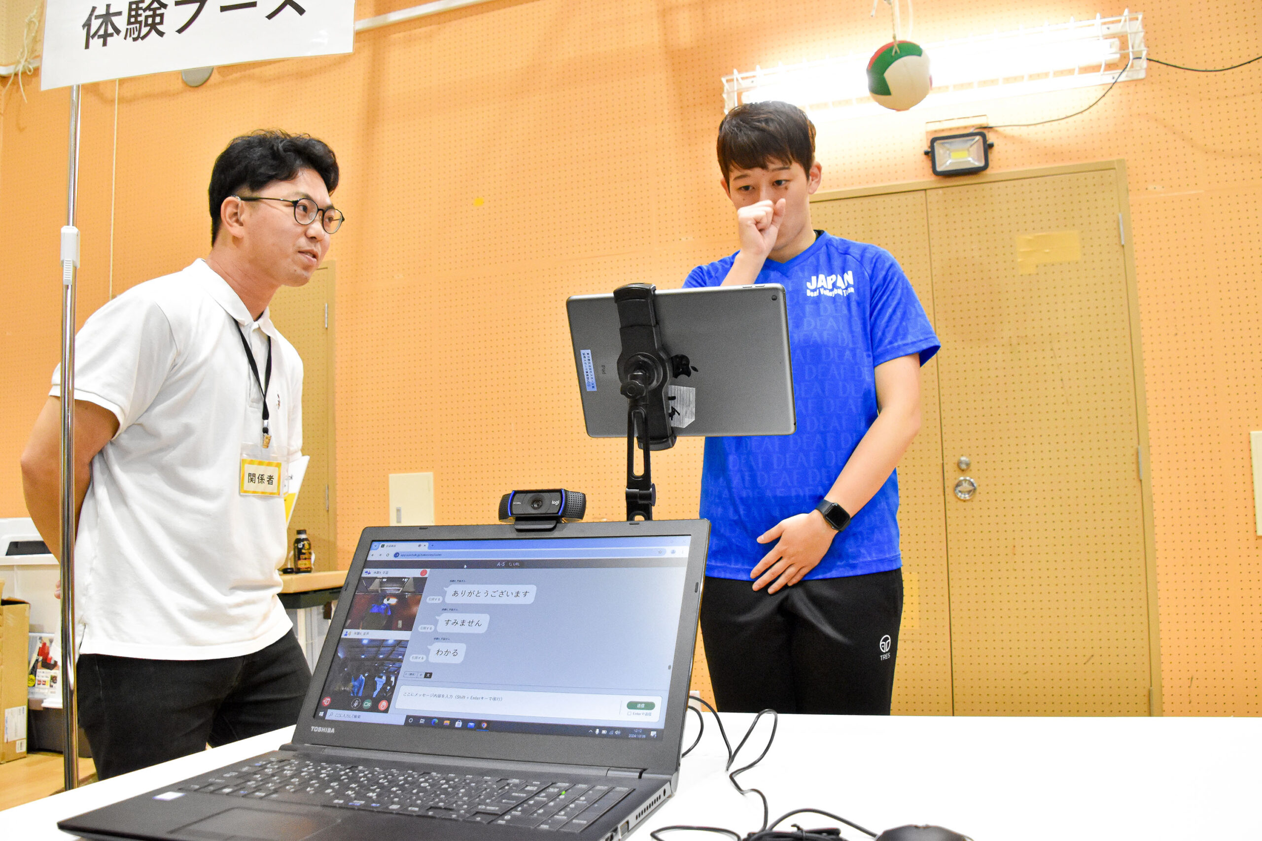 タブレットの前で右手の拳を顔の前にしている中田選手の写真