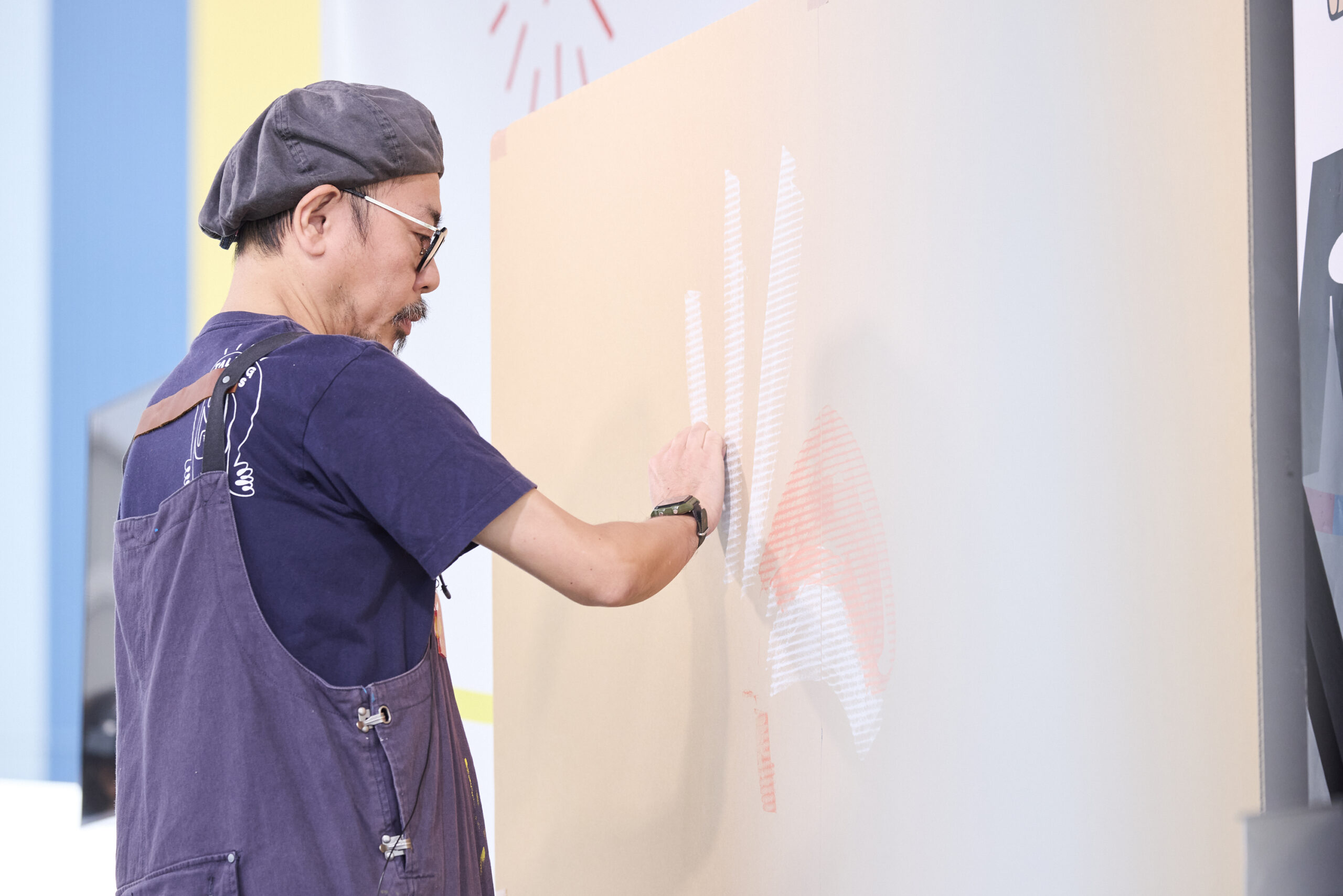 門さんが壁に絵を描いている写真