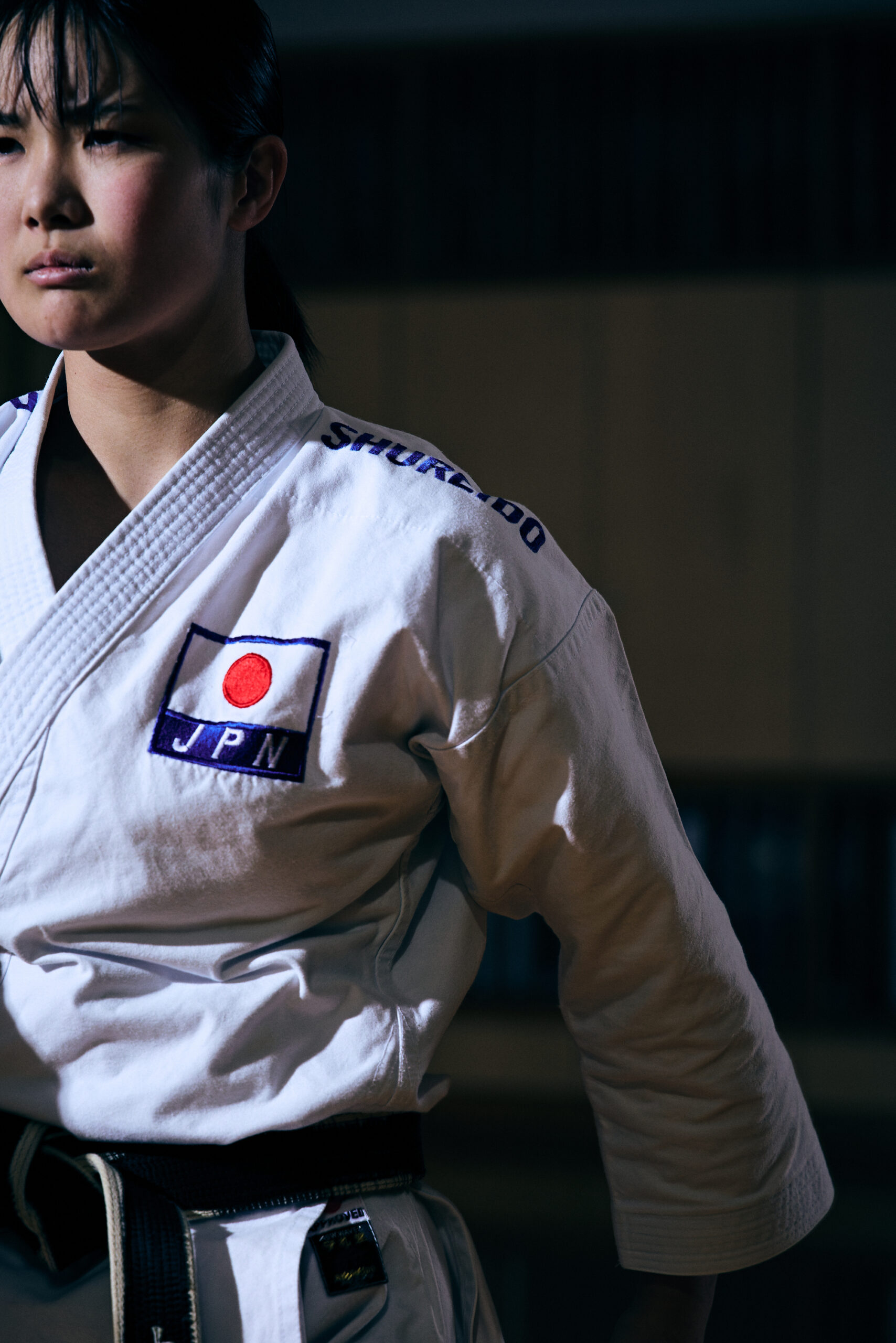 The photo of Ogura in her karate uniform with a stern look on her face, staring off into space.